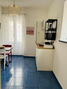 a room with a kitchen with a table and a refrigerator at MARIMA' la Casa Vacanze - Holidays Suites in Maratea