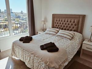 a bedroom with a bed with two towels on it at Maju in Neuquén
