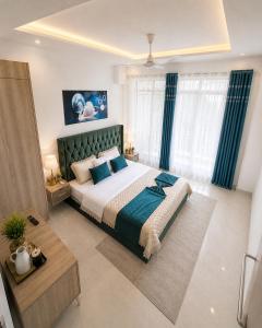 ein Schlafzimmer mit einem großen Bett und blauen Vorhängen in der Unterkunft El Classicoo Apartment in Rubavu