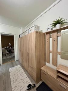 a room with wooden cabinets and a dining room at Tulipán Apartman Csongrád in Csongrád