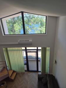 a room with two large windows in a house at Gonik NN Apartmani in Veliko Gradište +1 photo