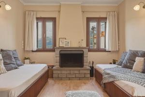 a living room with two beds and a tv at Metsovo Fireplace Retreat 2 in Metsovo
