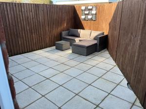 a patio with a couch on a wooden fence at Jayslin in Felpham