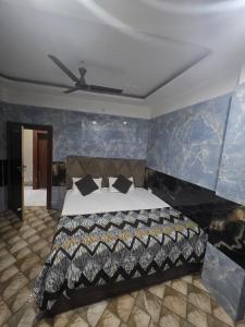a bedroom with a large bed with blue walls at Tulsi Dham in Vrindāvan