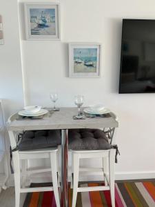 a dining room table with two wine glasses on it at Jayslin in Felpham