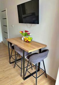 a wooden table with a bowl of fruit and flowers on it at Apartment Eva Hvar in Hvar