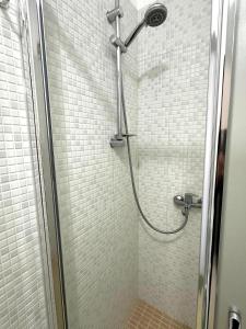 a shower with a shower head in a bathroom at Eri Apartments 4 in Shëngjin +87 photos