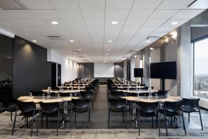 ein Esszimmer mit Tischen und Stühlen und einem großen Fenster in der Unterkunft Hôtel Alt Quartier DIX30 in Brossard