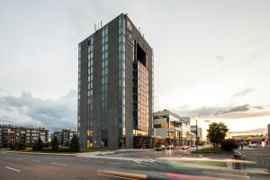 ein hohes Glasgebäude in einer Stadtstraße in der Unterkunft Hôtel Alt Quartier DIX30 in Brossard