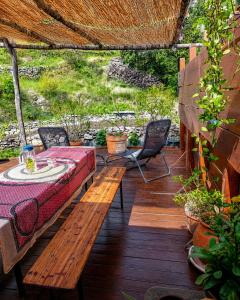 a patio with a bench and a table and chairs at Cocon-ardechesauvage in Pont-de-Labeaume