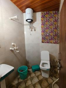 a small bathroom with a toilet and a sink at Tulsi Dham in Vrindāvan