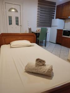 un letto bianco con un asciugamano sopra in cucina di Basilis room a Loutsa Altre 32 foto