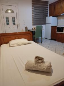 una camera da letto con un letto con un asciugamano sopra di Basilis room a Loutsa