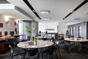 ein Restaurant mit Tischen und Stühlen in einem Raum in der Unterkunft Hôtel Alt Quartier DIX30 in Brossard