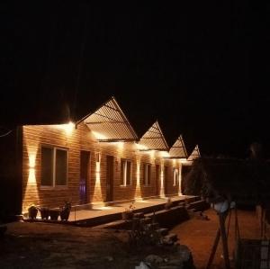 a row of wooden houses at night with lights at Chautari Hotel & Restaurant in Astam +6 photos