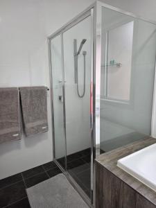 a glass shower in a bathroom with a sink at Quiet Homestay Ulladulla in Ulladulla