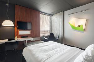 ein Schlafzimmer mit Bett, Schreibtisch und Fernseher in der Unterkunft Hôtel Alt Quartier DIX30 in Brossard + 35 Fotos
