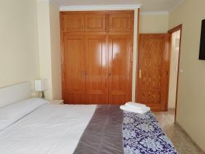 a bedroom with a bed and a wooden closet at Casa Susan's in Águilas