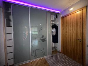 a room with a glass door with a purple light at Andrea Apartamenti in Jūrmala