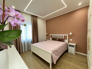 a bedroom with a bed and a plant with purple flowers at CR home in Pompei in Pompei