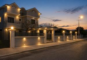 a house with a fence and lights on a street at Diamond Rod Villa near Faliraki in Kalithies