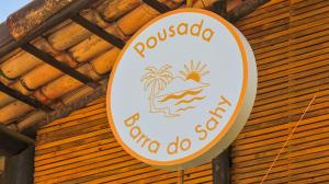 a sign for a restaurant with a beach and palm trees at Pousada Barra do Sahy in Barra do Sahy