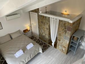 a bedroom with a bed and a stone wall at Casa Collina - Grottino in Pisticci