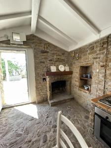 a kitchen with a stone fireplace and a window at Casa Collina - Grottino in Pisticci +35 photos