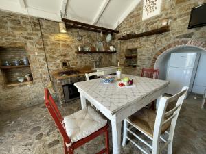 a kitchen with a table and chairs in a room at Casa Collina - Grottino in Pisticci