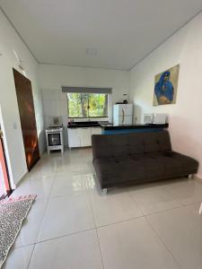 a living room with a couch and a kitchen at Hotel Camping R Formoso in Bonito