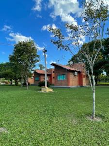 a house with a tree in the yard at Hotel Camping R Formoso in Bonito