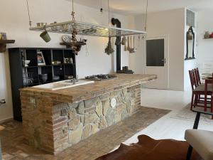 a kitchen with a stone counter with a sink at Casa Collina - Isola in Pisticci