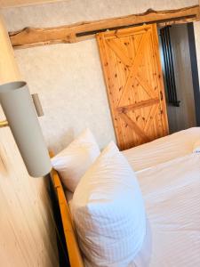 a bedroom with a bed with a wooden door at HACIENDA & Królicza Nora in Zatory