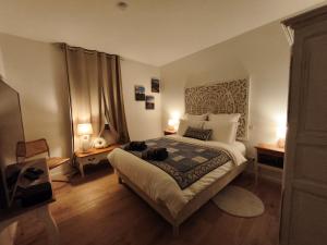 a bedroom with a bed with two cats laying on it at VILLA ADOYA Chambre d'hôtes Aigues-Mortes intra muros au calme climatisation réversible PISCINE WIFI ascenseur PARKING gratuit in Aigues-Mortes