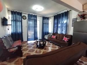 a living room with a couch and chairs and blue curtains at Blue Horizon Villa in Grand Baie in Grand-Baie +13 photos
