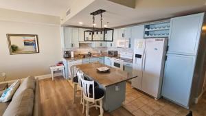 a kitchen with a couch and a table and a refrigerator at Stunning Gulf View Condo - Direct Beach Access - Stunning Sunsets in Panama City Beach +30 photos