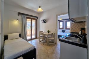 a small kitchen with a sink and a table at Sifakis House in Parga