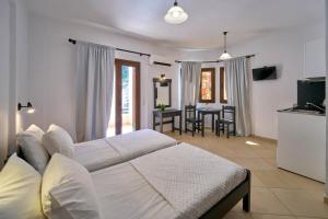 a bedroom with a bed and a kitchen with a table at Sifakis House in Parga