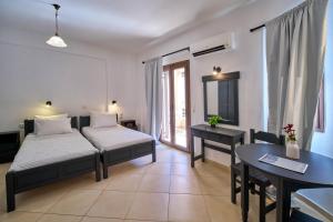 a bedroom with a bed and a desk and a table at Sifakis House in Parga