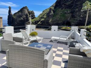 a patio with chairs and a view of the ocean at Rdj B in Porto Moniz