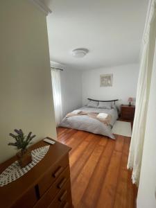 a bedroom with a bed and a wooden floor at Rdj B in Porto Moniz