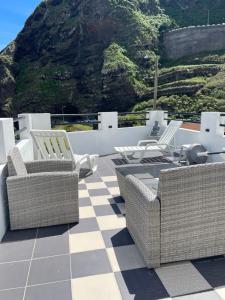 a patio with wicker chairs and a checkered floor at Rdj B in Porto Moniz +10 photos