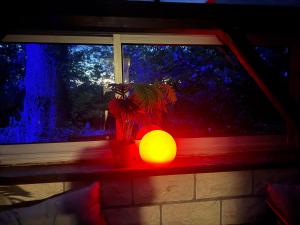 a orange light sitting on a window sill next to a plant at studio gien in Gien