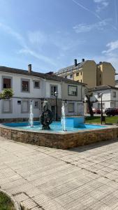 a fountain in the middle of a street with buildings at Ana in Burela de Cabo