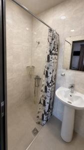 a bathroom with a shower curtain and a sink at Yolyans Hotel in Goris