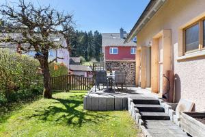 a patio with a table and chairs in a yard at Ferienwohnung am Brändbach in Bräunlingen