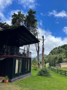 a house with a black roof in a field at Casa Bajareque in Cerro Punta