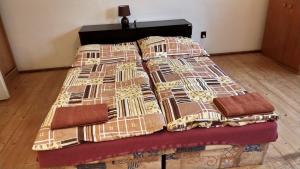 a bed with four pillows on top of it at Apartmán Andels I in Rakovník
