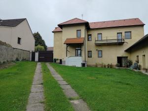 a house with a grassy yard in front of it at Apartmán Andels I in Rakovník