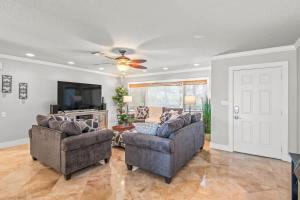 a living room with two couches and a tv at Clearwater Calling in Clearwater Beach